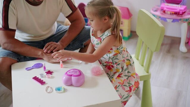 Daughter and father role-playing manicure salon