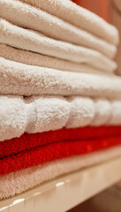 Stack of white and red towels on a shelf in the bathroom - 765695861