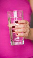 Closeup of glass with crystal clean water in the girl's hand. Healthy nutrition and lifestyle - 765696683