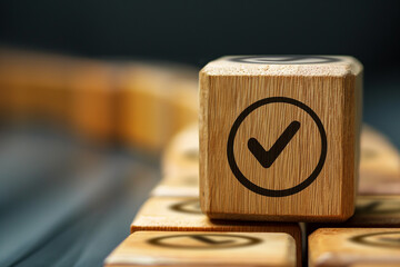 Wooden cube with a check mark on a dark background. The concept of approval, verification, and correctness.
