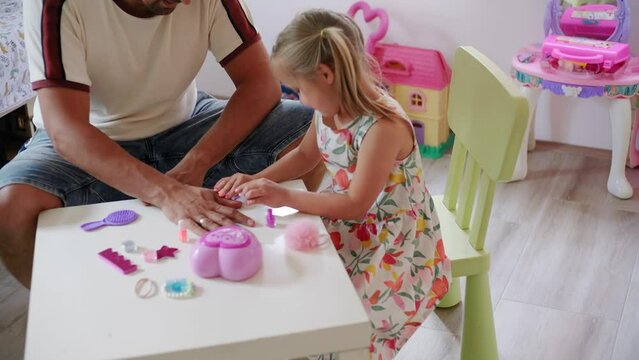 Daughter and father role-playing manicure salon