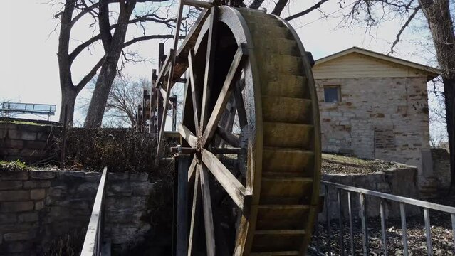 Waterwheel turns with stone building in background