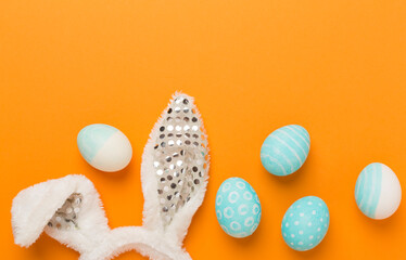 Blue easter eggs with bunny on color background, top view