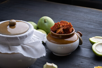 Homemade Mango Pickle or aam ka achar Kairi Loncha stored or preserved in China clay pot with Ingredients. - obrazy, fototapety, plakaty