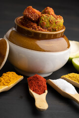 Homemade Mango Pickle or aam ka achar Kairi Loncha stored or preserved in China clay pot with...