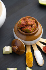 Homemade Mango Pickle or aam ka achar Kairi Loncha stored or preserved in China clay pot with...