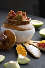 Homemade Mango Pickle or aam ka achar Kairi Loncha stored or preserved in China clay pot with...