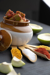 Homemade Mango Pickle or aam ka achar Kairi Loncha stored or preserved in China clay pot with...