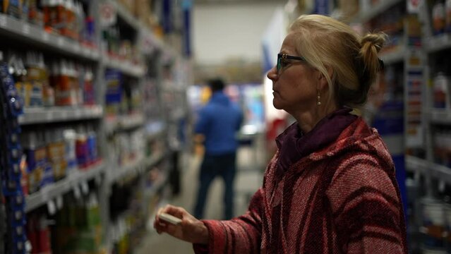 Closeup of woman in large hardware store looking at all the products available for home improvement remodeling projects.