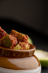 Homemade Mango Pickle or aam ka achar Kairi Loncha stored or preserved in China clay pot with...