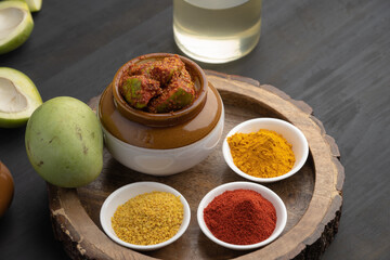 Homemade Mango Pickle or aam ka achar Kairi Loncha stored or preserved in China clay pot with...