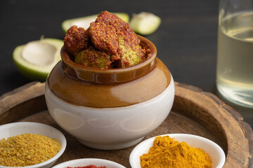 Homemade Mango Pickle or aam ka achar Kairi Loncha stored or preserved in China clay pot with...