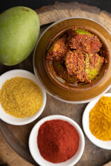 Homemade Mango Pickle or aam ka achar Kairi Loncha stored or preserved in China clay pot with...