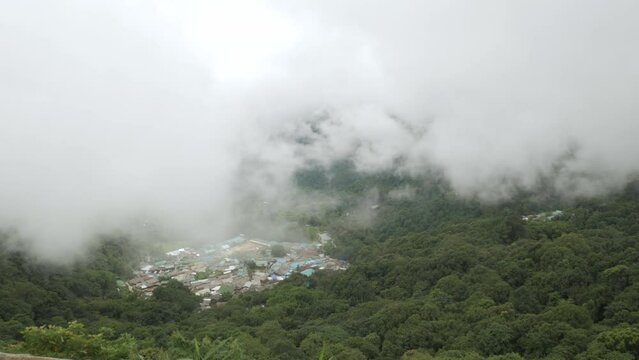 aerial view from doi pui view point to the local village among the mountain range hill valley with white cloud and fog over the village