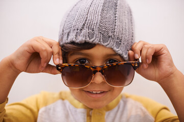Child, portrait and sunglasses with cool style and confidence with kid in a home. Happy, eyewear and youth fashion with an hipster boy with modern and casual accessory in a house with fun and frames