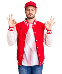 Young handsome man wearing baseball jacket and cap relax and smiling with eyes closed doing meditation gesture with fingers. yoga concept.