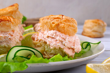 Smoked trout pate with cream cheese between puff pastry buns served on salad. Exquisite appetizer 