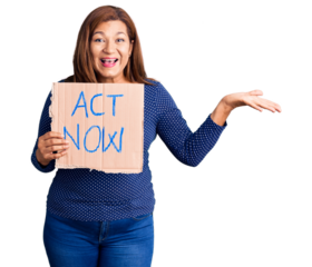 Middle age latin woman holding act now banner celebrating victory with happy smile and winner expression with raised hands
