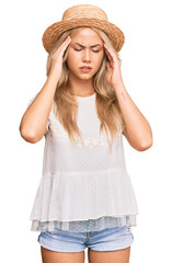 Obraz na płótnie Canvas Young blonde girl wearing summer hat with hand on head for pain in head because stress. suffering migraine.