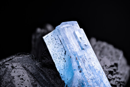 Aquamarine (blue beryl) on schorl (black tourmaline) macro photography detail texture background. From Namibia. close-up raw rough unpolished semi-precious gemstone 