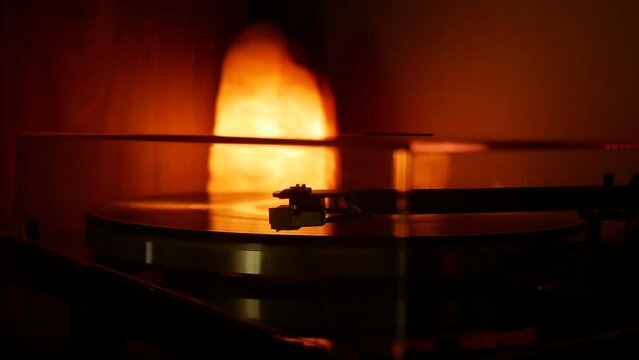 Headshell with the needle of the record player slowly lowers onto the vinyl record.