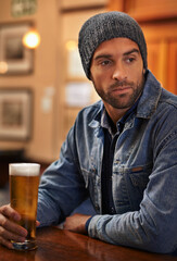 Fototapeta na wymiar Beer, thinking and male person at pub for drinks, restaurant and entertainment for fun. Pensive, alcohol and cafe for thoughtful or social for relax, pub and beanie for cold weather in England