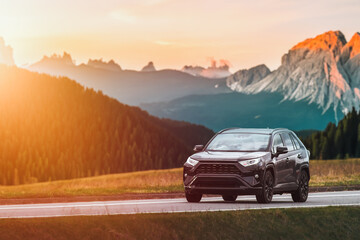 Fototapeta na wymiar Family SUV Car on Scenic Road with Sunset Backdrop