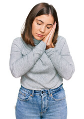 Fototapeta premium Young beautiful woman wearing casual turtleneck sweater sleeping tired dreaming and posing with hands together while smiling with closed eyes.
