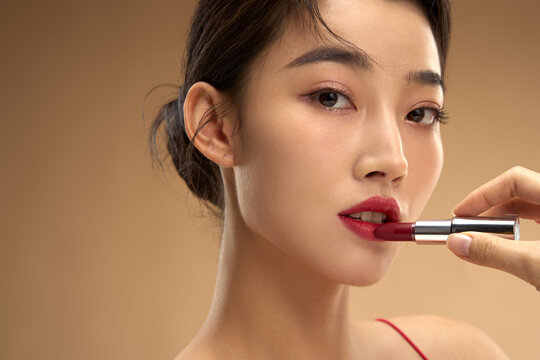 Young and beautiful women apply makeup and lipstick
