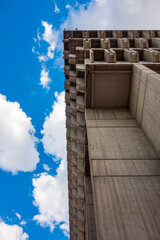 Boston City Hall, the towering, top heavy, brutalist government building on a partly cloudy day.