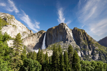Yosemite National Park...Granite rocks and a pine forest frame Upper Yosemite Fall in a thunderous...