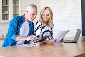 Middle aged couple calculate profits of finance account together