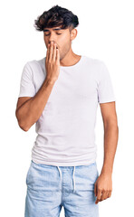 Young hispanic man wearing casual clothes bored yawning tired covering mouth with hand. restless and sleepiness.