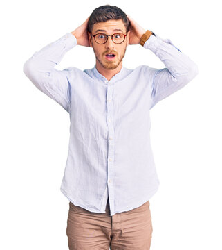 Handsome young man with bear wearing elegant business shirt and glasses crazy and scared with hands on head, afraid and surprised of shock with open mouth