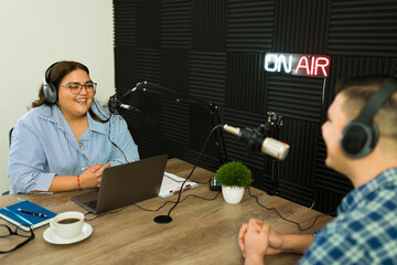 Cheerful podcast host with a guest in her talk show podcast