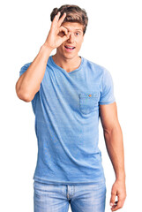 Young handsome man wearing casual clothes doing ok gesture with hand smiling, eye looking through fingers with happy face.