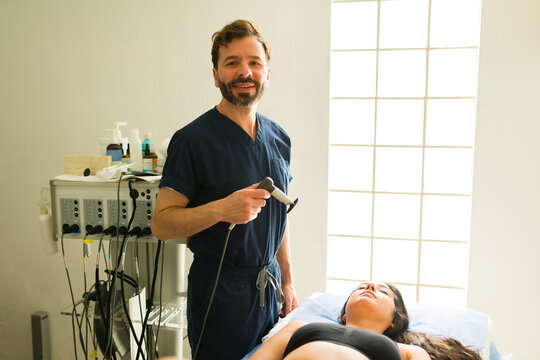 Smiling doctor using hyperthermia tecar therapy