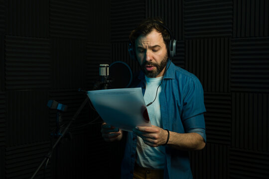 Caucasian voice actor recording in soundproof studio
