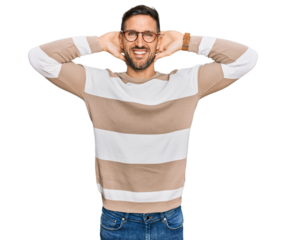 Handsome man with beard wearing casual clothes and glasses relaxing and stretching, arms and hands behind head and neck smiling happy