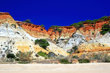 Red rocks on Rock Algarve Praia da Falesia in Portugal with nice blue sky to take a long beach...