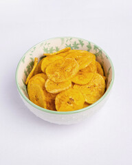 Green banana chips on white background