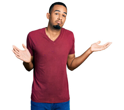 Young african american man wearing casual t shirt clueless and confused with open arms, no idea and doubtful face.