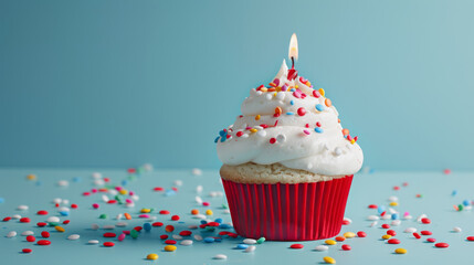 A festive birthday cupcake with a lit candle and colorful sprinkles.