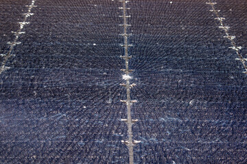 Close up view of damaged broken solar panel tempered glass cell. Stone dent in the middle with spiderweb cracks around.