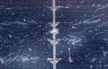 Close up view of damaged broken solar panel tempered glass cell. Stone dent in the middle with...