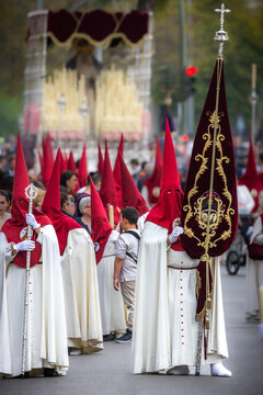Nazareno, bearer in a procession of the easter week in Seville, andalusia, Spain. 2024 Semana Santa. Red hood, procession of 23.03.2024