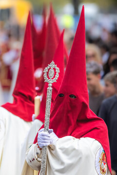 Nazareno, bearer in a procession of the easter week in Seville, andalusia, Spain. 2024 Semana Santa. Red hood, procession of 23.03.2024