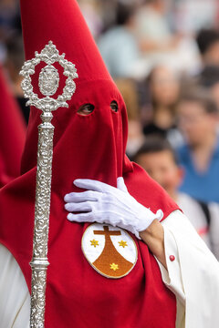 Nazareno, bearer in a procession of the easter week in Seville, andalusia, Spain. 2024 Semana Santa. Red hood, procession of 23.03.2024