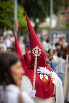 Nazareno, bearer in a procession of the easter week in Seville, andalusia, Spain. 2024 Semana Santa. Red hood, procession of 23.03.2024