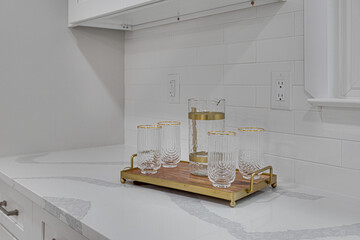 Set of Ribbed Glassware on Wood Brass Cutting Board on Marble Countertops, White Subway Tile Backsplash